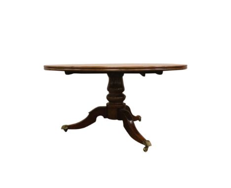 the twin topped table resting on a turned pod terminating on a tripod base with sabre legs and lion paw toe castors, the fitt