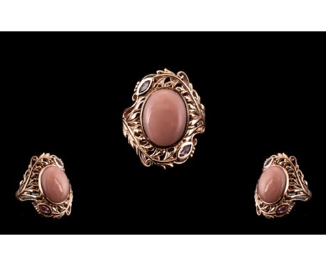 Pink Opal and Pink Sapphire Statement Ring, an oval cut cabochon of pink opal, measuring 7cts, set in an openwork, curved fea