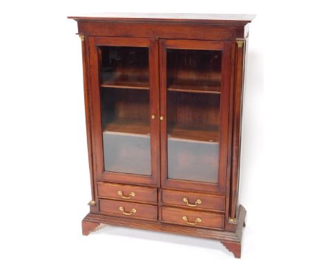 A Regency style mahogany bookcase, the plain top raised above two glazed doors with bevelled glass revealing plain shelves ab
