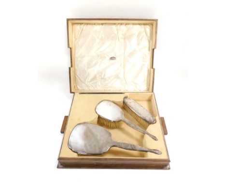 A George V silver backed four piece dressing table set, with engine turned decoration, cased, comprising hair and clothes bru