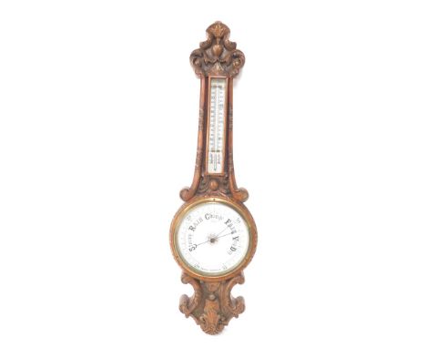 A Victorian oak cased aneroid barometer, with thermometer, carved with foliate scrolls, 88cm high.