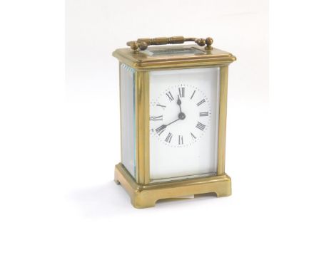 A French brass cased carriage clock, by R &amp; Company Paris, white enamel dial bearing Roman numerals, the case of conventi