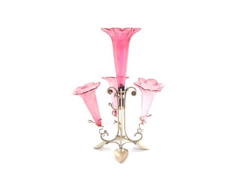 A Victorian silver plate and cranberry glass epergne, with four glass trumpets, raised on a scrolling base with floral and fo