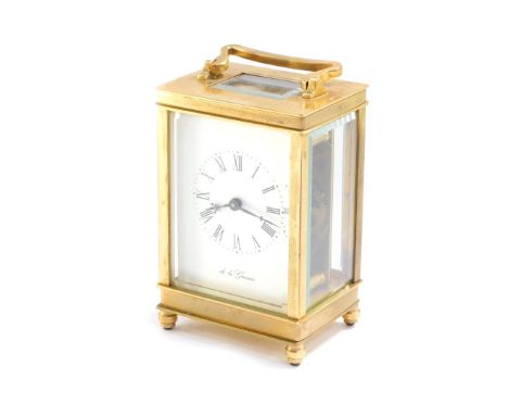 A brass carriage clock by De la Grense, of conventional form, dial bearing Roman numerals, case presentation engraved, with k