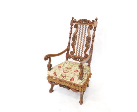 A 19thC heavily carved walnut throne type armchair, with a pierced floral and scroll cresting rail, egg and cup finial, verti