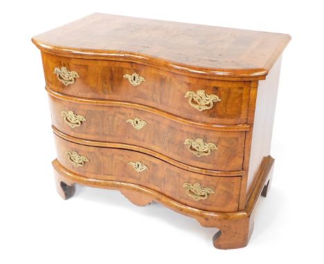 An early 19thC Dutch walnut serpentine chest, with deep cross banded and moulded top over three drawers, with brass pressed l