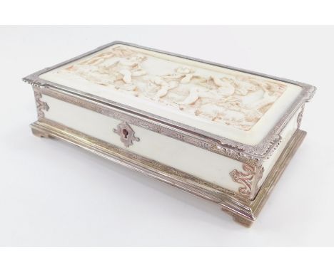 A Victorian silver and ivory box, of rectangular form, the lid heavily carved with three cherubs playing musical instruments 