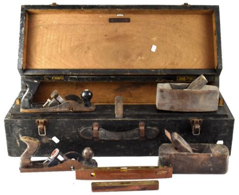 A vintage wooden toolbox with leather handle containing four vintage hand planes.