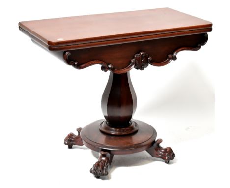 A 19th century mahogany fold-over tea table, the rounded rectangular top above a carved shaped apron, raised on a hexagonal b