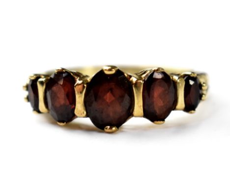 A vintage 9ct gold garnet ring, set with five graduated oval cut garnets on a 9ct yellow gold shank, size P, approx. 3.4g.