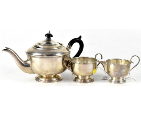 A George V hallmarked silver three-piece tea set comprising teapot, height 16cm, milk, height 8.5cm and sugar, of standard de