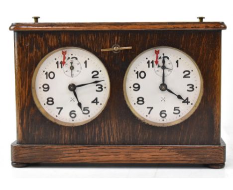 A vintage wooden cased chess clock, white enamel dials with Arabic numerals, with brass stop buttons. CONDITION REPORT Clock 