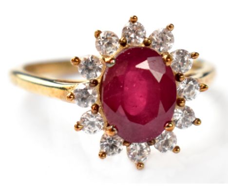 A 9ct gold ruby ring the large central claw set ruby set within a halo of white stones, on 9ct gold shank, size Q, approx 2.8