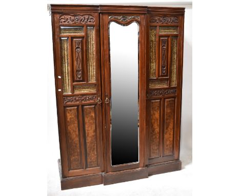 A Victorian walnut triple break-front wardrobe, the central door with bevelled mirror plate flanked by pair of part glazed do