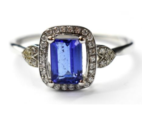 A modern 14ct white gold Tanzanite ring, the central emerald cut stone, clarity VS, colour AAA minimum, approx 0.95ct, protru