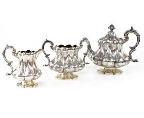 A Victorian hallmarked silver three-piece tea set of lobed form, with engraved decoration, comprising a teapot, twin-handled 