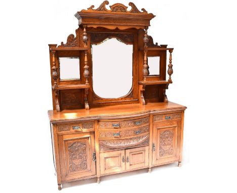 A large Victorian carved oak mirror back sideboard, the upper section mounted with a broken swan neck pediment carved with ac