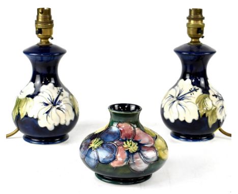 A pair of Moorcroft short lamp bases decorated with white tube-lined 'Hibiscus' pattern on a blue ground, height to top of li
