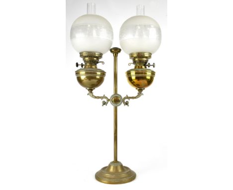 An Edwardian brass twin-branch oil lamp, central column with outswept arms supporting brass oil reserve, to circular stepped 