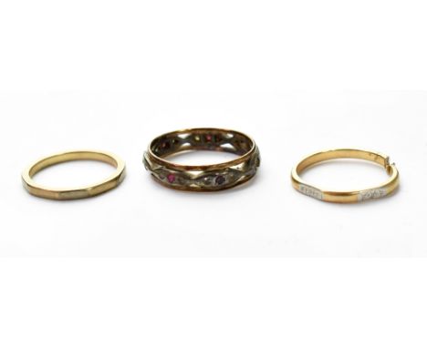 Three 9ct gold band rings to include a ruby and white stone eternity ring and two thin bands, one example has been cut, appro