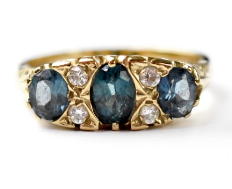 A vintage 9ct gold fashion ring set with three oval cut blue stones separated with two columns of two tiny white stones, size