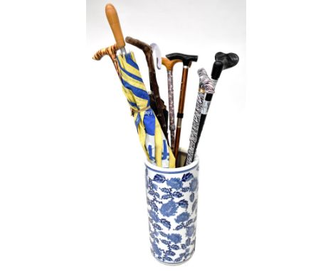 A blue and white ceramic umbrella stand in the Chinese Chinoiserie style, a vintage metal umbrella stand in the form of an up