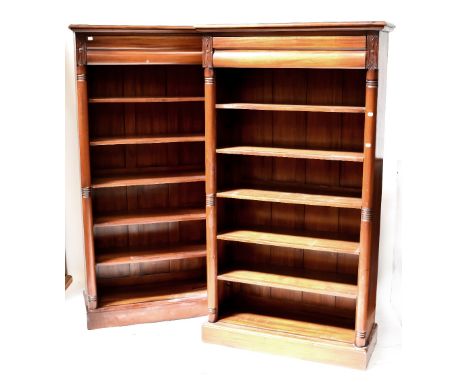 A pair of 20th century Edwardian-style mahogany bookcases, stepped frieze above two carved rectangular plaques, to turned pil