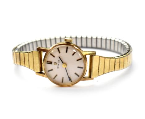 Omega; a ladies' 9ct gold vintage Omega wristwatch, the silvered dial set with baton numerals, on gold-plated flexi strap.