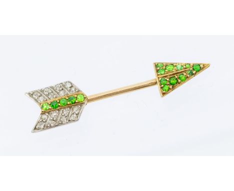 An Art Deco diamond and demantoid garnet jabot pin brooch, arrow form pave set with round cut garnets to the arrow tip and fl