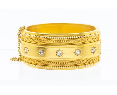 A Victorian Etruscan Revival diamond set yellow metal bangle, with a central row of five star set graduated old mine cut diam