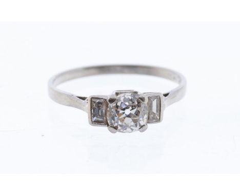 An Art Deco diamond and platinum three stone ring, comprising a claw set old cut diamond set to the centre, approx 0.80ct, as