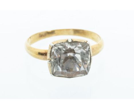 A 19th century rock crystal and yellow metal ring, the cushion cut rock crystal set to a cut down backed setting, to a later 