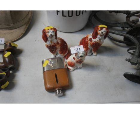 Three Staffordshire dog ornaments; together with a hip flask