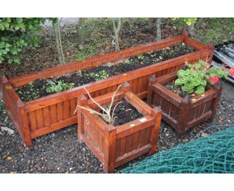 An oblong garden planter and a pair of wooden planters