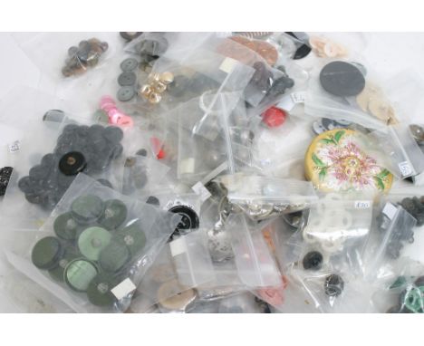 A box of various buttons and a compact