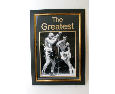 A framed Muhammad Ali boxing poster signed in gold pen. the item measures 34" x 24" and is framed in gold and black. THis com