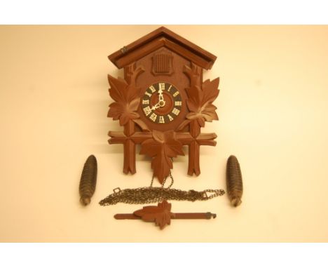 A small Black Forrest type cuckoo clock with simulated pine cone weights
