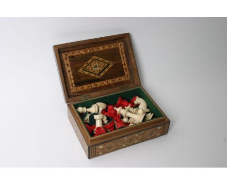 An inlaid Tunbridge Ware style box containing a carved and stained bone chess set