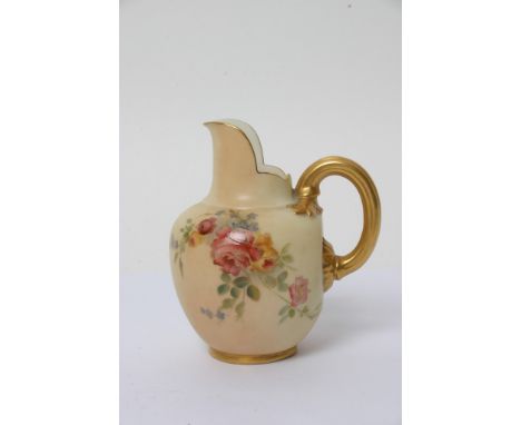 A small Royal Worcester blush ivory jug decorated with flowers and having gilt handles