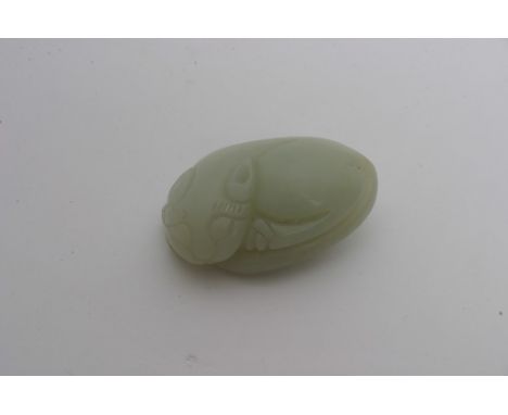 A Chinese pale green jade carving in the form of a reclining stylised cat. Length: 5cm approximately