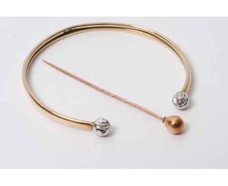 A gold stick pin and bangle