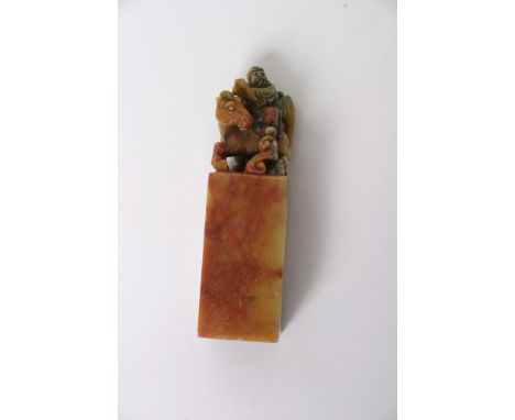 A Chinese carved soapstone seal surmounted by a figure on horseback. Height: 10.5cm approximately
