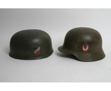 A German Third Reich M40 helmet together with a German paratroopers helmet