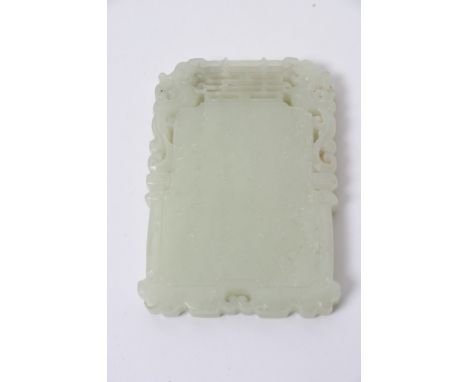 A Chinese green hardstone tablet with pierced rim and raised Chinese script and figures, possibly Jade. Length: 7.5cm approxi