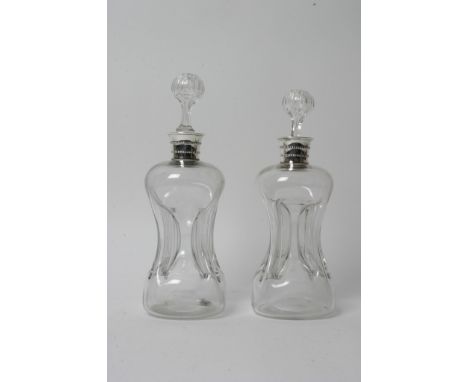 A pair of pinched glass decanters with silver mounts, hallmarks for Edward Hutton, London 1891