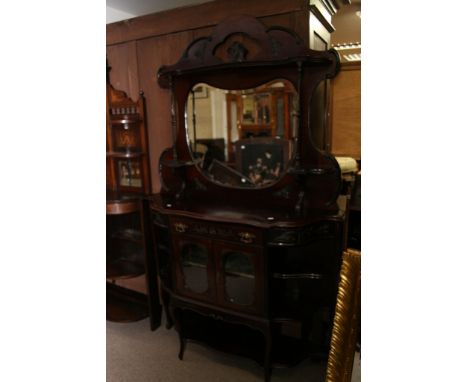 An Edwardian mahogany chiffonier the raised back with mirror inset above a single drawer, glazed doors and under shelf 