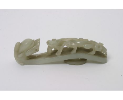 A Chinese carved jade belt hook with raised and carved mythical beast