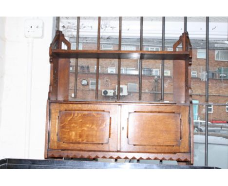 An oak hanging shelf fitted with cupboards