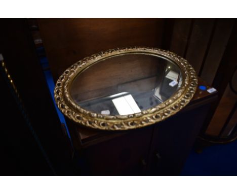 A gilt frame oval wall mirror