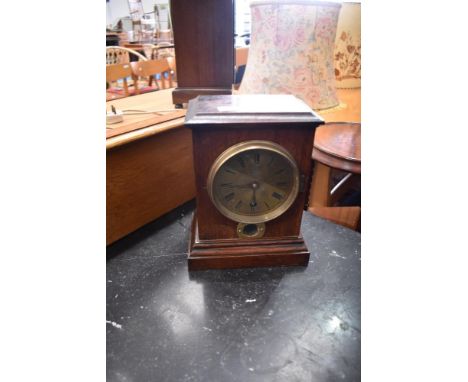 An oak cased mantel clock with brass roman numeral dial